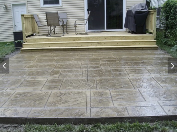 Stamped patio by backyard deck